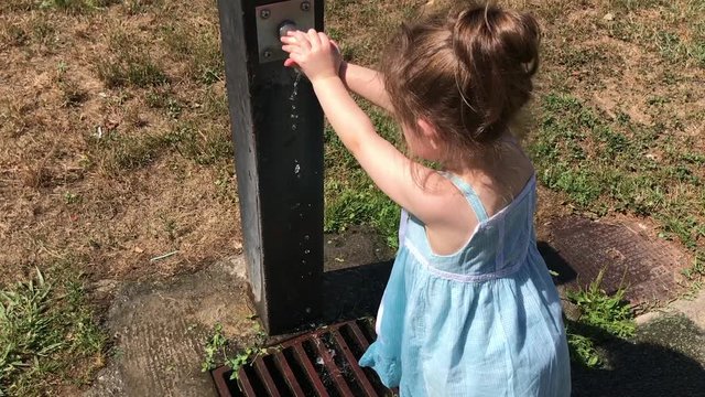 Ni&ntilde;a peque&ntilde;a jugando con una fuente de agua.