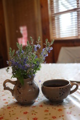 A cup of coffee and a vase of flowers on a table