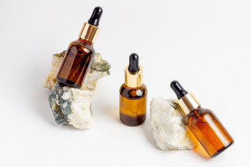 Obraz premium Amber Bottle for essential oils and cosmetic products. Glass bottle on white background. A dropper, a bottle with a sprayer
