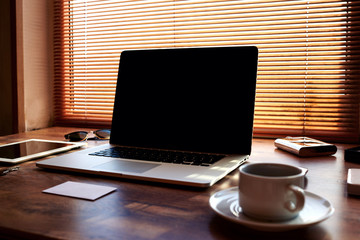 Fototapeta premium Mock up of modern freelancer workplace with luxury accessories and work tools,cup of american coffee, envelope, tablet and laptop computer with blank copy space for text message or advertising content