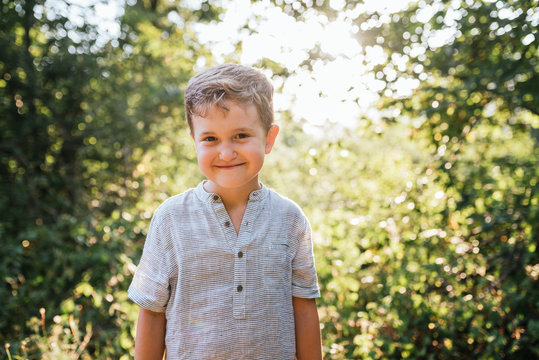 6-year-old boy smiles in the woods
