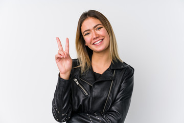 Young caucasian woman wearing a black leather jacket showing number two with fingers.