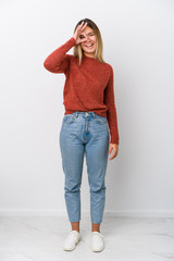 Full body young caucasian woman excited keeping ok gesture on eye.