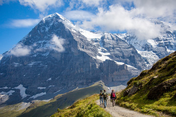 Fototapeta na wymiar Hikers on the The Eiger trail and The Eiger, a 3,967-metre (13,015 ft) mountain of the Bernese Alps, overlooking Grindelwald and Lauterbrunnen in the Bernese Oberland of Switzerland