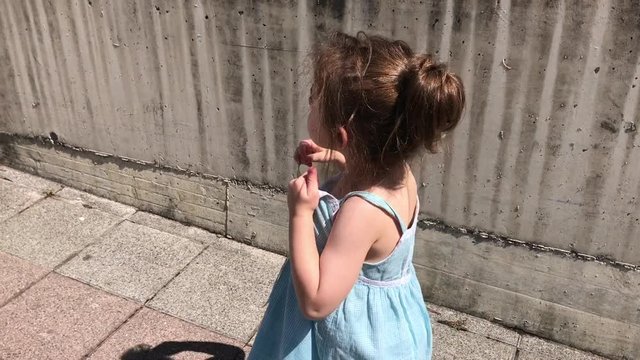 Ni&ntilde;a andando al lado de una pared