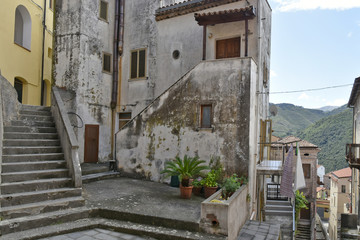 Fototapeta na wymiar A narrow street among the old houses of Tortora, a rural village in the Calabria region, Italy.