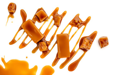 Caramel candies with caramel sauce isolated on a white background close up. Melted sweet  toffee...
