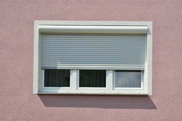 Moderne Fenster in einer gemauerten, verputzten und gestrichenen Fassade eines modernen Wohnhauses