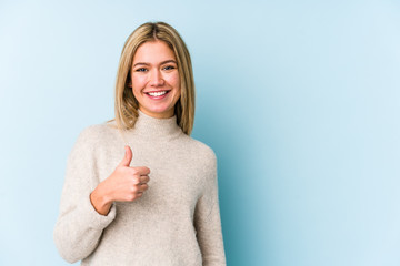 Young blonde caucasian woman isolated smiling and raising thumb up