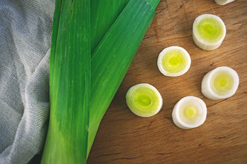 Green leek whole and sliced on the wooden table. Organic food. Organic vegetables. Vegetarian food...