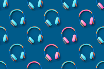 Seamless pattern of blue and pink colored headphones on blue background. Minimalistic fashion music concept. Trendy color of the year concept. Top view, flat lay