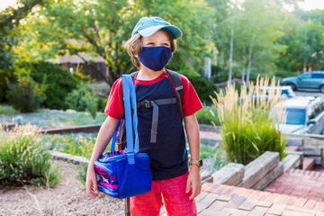 portrait of 7 year old boy wearing face mask, ready for school