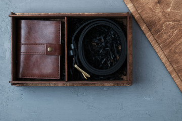 Gift set mens accessories close-up in wooden box on dark concrete background