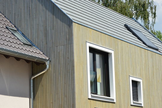 Fassade eines modernen neu gebauten Einfamilien-Wohnhauses verblendet mit lasierten Holzplanken