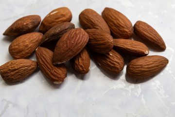 Brown almond grains lie on a white background.