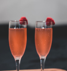 Sparkling drink in wine glass with raspberry 