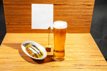 Anchovy tapa dish with a fresh glass of beer and empty banner