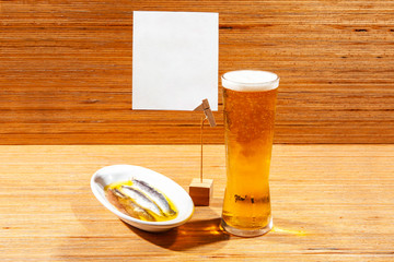 Anchovy tapa dish with a fresh glass of beer and empty banner