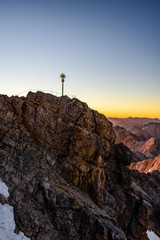 Fototapeta premium A beautiful and colorful sunrise on the summit of the highest mountain in Germany, Zugspitze at 2962m. 