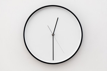  white wall clock hanging on a white wall