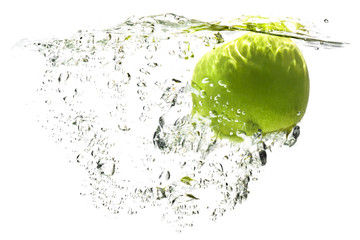 one green apple falling into water on a white background with splashes, drops and bubbles.