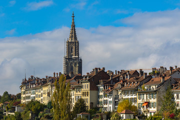 Naklejka premium Beautiful view of Bern old town with the tower of Bern Minster (Münster) cathedral on a sunny autumn day with blue sky and cloud, Switzerland