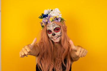 Young blonde woman over isolated background approving doing positive gesture with hand, thumbs up smiling and happy for success. Looking at the camera, winner gesture.
