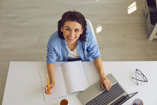 Top view of young woman taking online educational class or participating in web conference from home