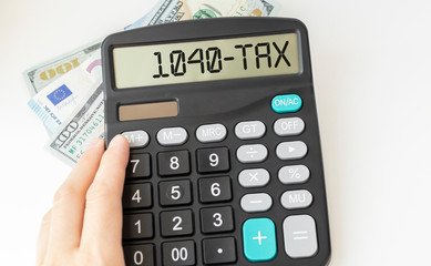Fototapeta na wymiar Word 1040-Tax on calculator. Business and tax concept.