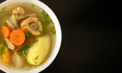 Shurpa soup in a white bowl on dark wooden background with copy space. Top view. Famous traditional Asian, Uzbek, Middle East soup with beef or lamb and vegetables. Shorpa, sherpa, chorba