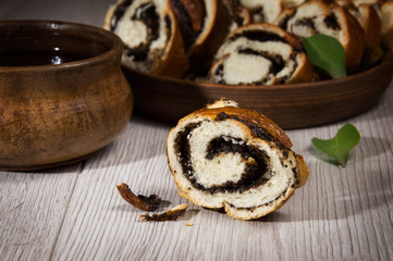 Roll with poppy seeds is cut into portions. Sweet pastries with poppy seeds on a ceramic plate breakfast with tea.
