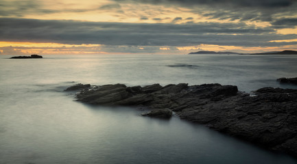 sunset over the sea in galicia and finisterre cape in the background