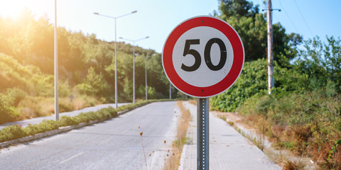 speed limit road sign in red circle on asphalt highway