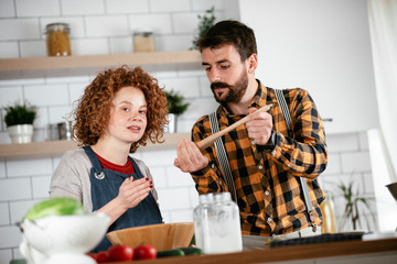 Boyfriend and girlfriend making delicious food at home. Loving couple cooking in kitchen.