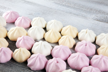 Meringue. Crispy white and pink twisted meringue. Concept love of sweet on table