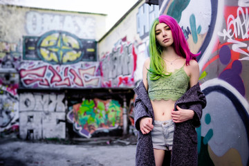 Naklejka premium Close-up Fashion woman portrait of a girl with green - pink hair. Summer street fashion.