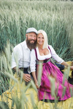 Smiling mature couple sitting amidst plants on land