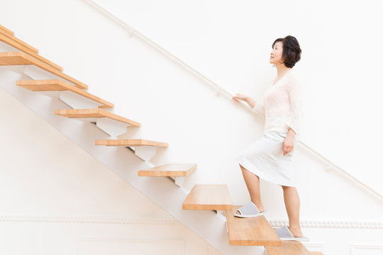 階段を上るシニア女性
