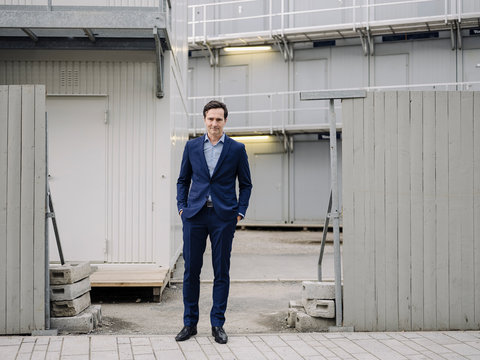 Portrait of a confident mature businessman standing at a construction site