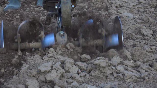 Tilling a vegetable garden with a rototiller in the spring instead of plughing
