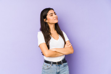 Young indian woman isolated on purple background dreaming of achieving goals and purposes