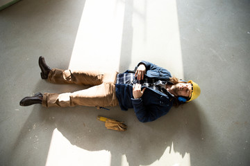Construction worker sleeping on floor in renovating house
