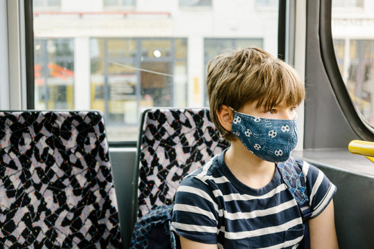 Boy wearing protective mask in tram