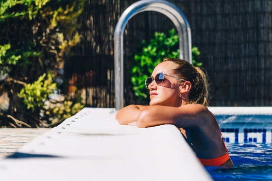 Woman enjoying sunlight at pool edge
