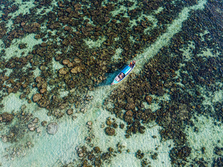 Thailand, Satun Province, Ko Lipe, Aerial view of fishing boat moored at rocky shore