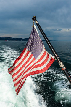 USA,&nbsp;Washington,&nbsp;American flag on back of moving motorboat