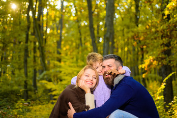 Fototapeta premium Young parents and children having picnic and relaxing together on an autumns sunny day. Happy family. Happy couple with kid outdoors. Family with boy. Happy family outdoors.