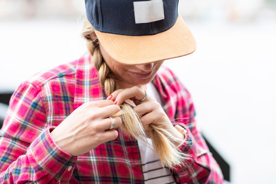 Close-up of mid adult woman wearing cap braiding hair