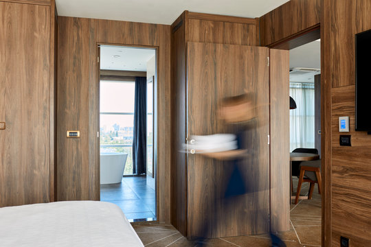 Blurred motion of chambermaid walking on hotel room