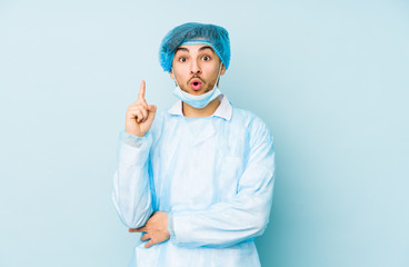 Young arabian surgeon man isolated against on a blue background having some great idea, concept of creativity.